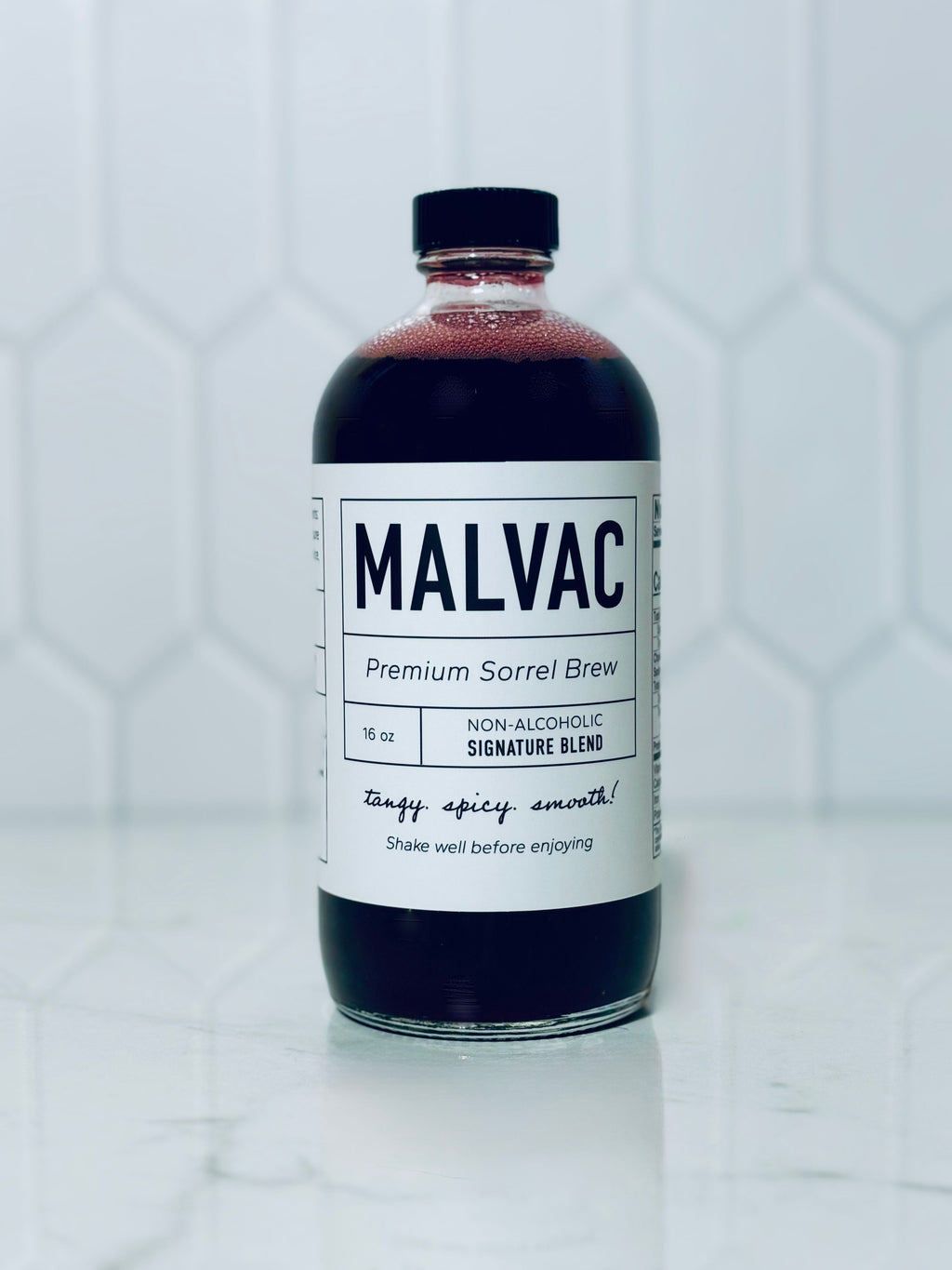 One bottle of MALVAC Premium Sorrel Brew Signature Blend on a white tiled background.