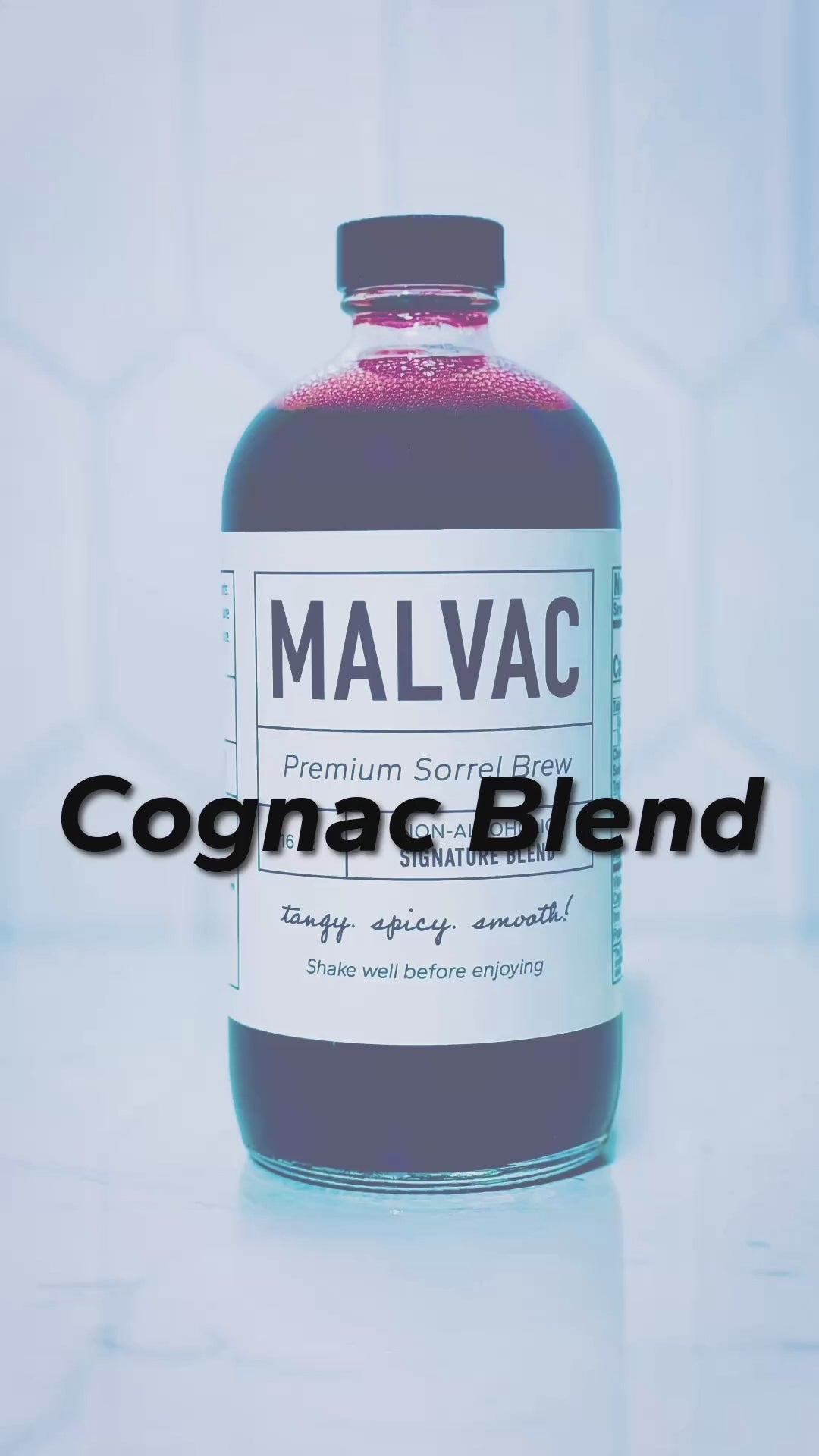 Cognac blend. Pouring Hennessy cognac and MALVAC Premium Sorrel Brew into a glass with a ball of ice and using a wooden device placed over the glass to infuse the drink with smoke from the burnt wood. Music playing in the background. 